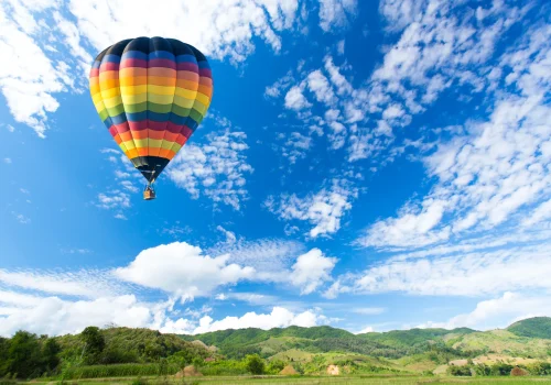globo-de-aire-caliente-colorido-sobre-campo-verde